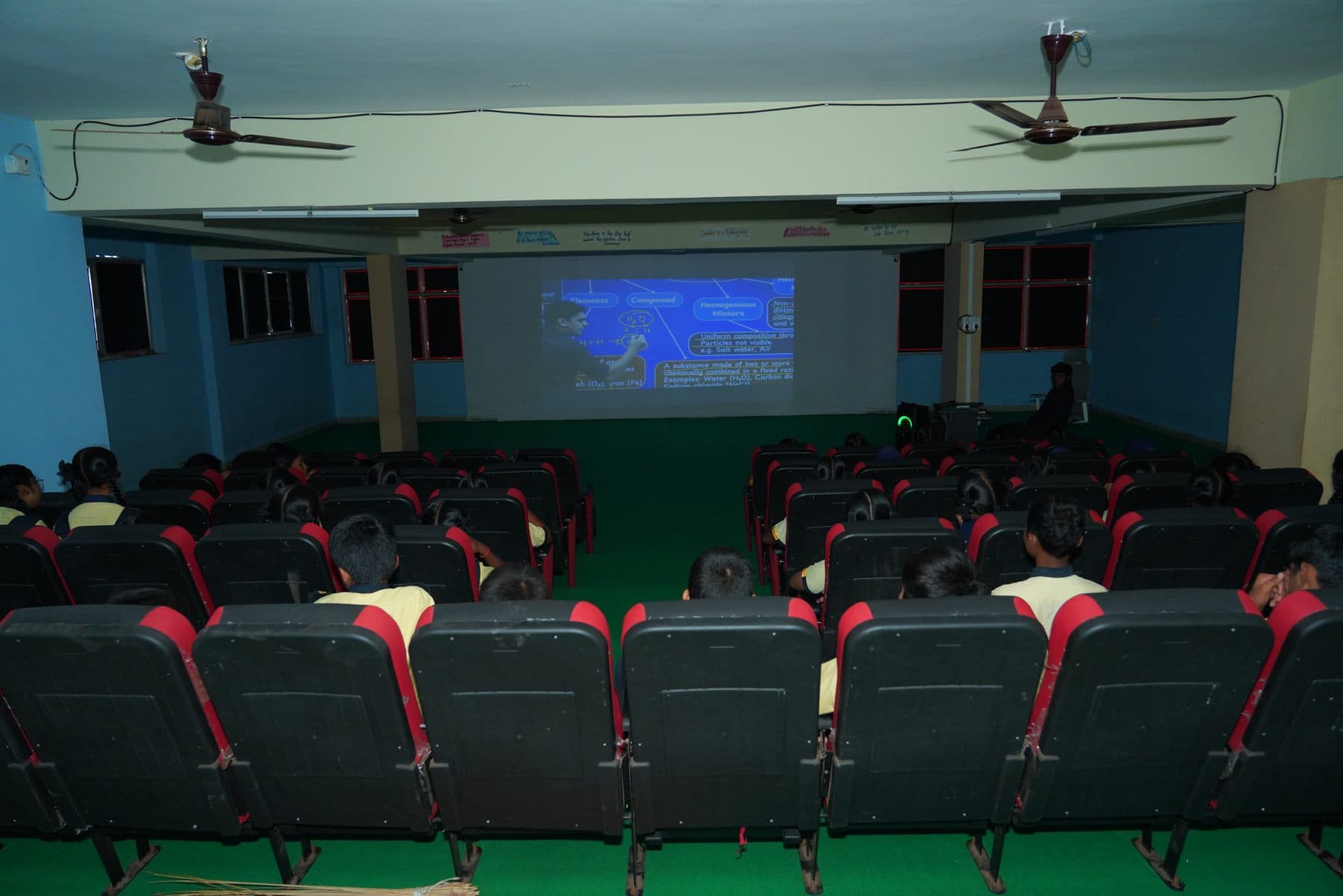 Students watching a projected lesson in the theater